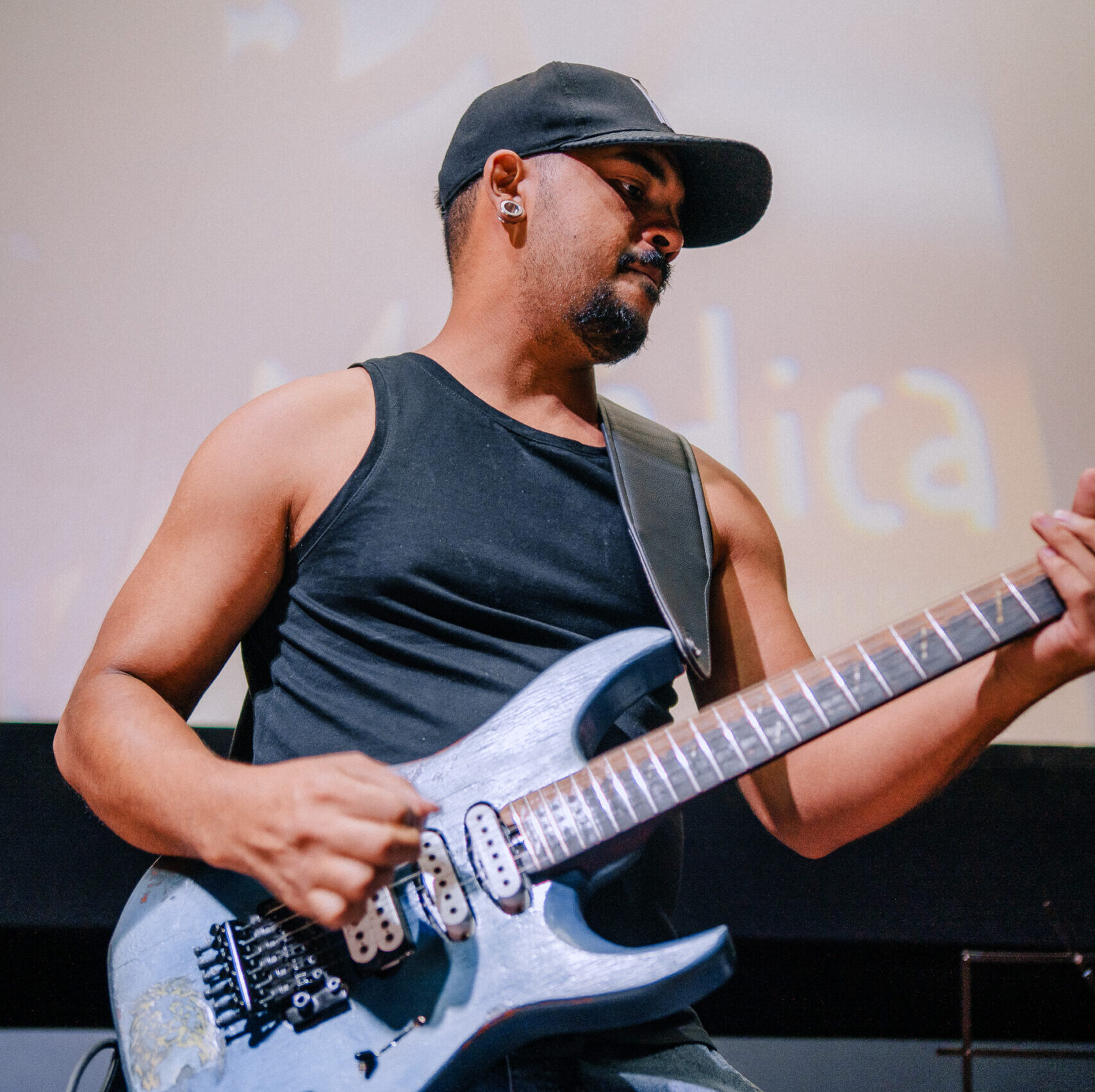 professor de guitarra tocando sua guitarra em pé